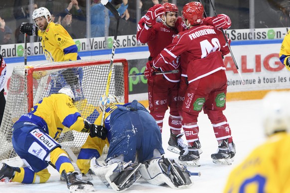 Les lausannois Yannick Herren, gauche en rouge, et Etienne Froidevaux celebrent le deuxieme but devant le gardien davosiens Gilles Senn, centre a terre, lors du 1er match du quart de finale de play of ...