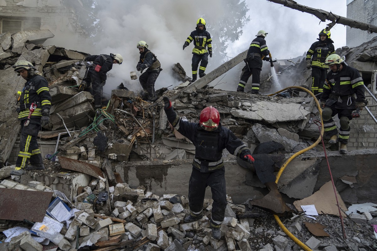 Rescue workers clearing rubble of a destroyed school after an attack in Kharkiv, Ukraine, on Monday, July 4, 2022. The Ukrainian military's General Staff says that Russian forces are trying to pr ...
