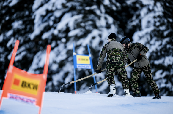 Swiss Army soldiers work on the race slope during the men's super-g race at the Alpine Skiing FIS Ski World Cup in Wengen, Switzerland, Friday, January 12, 2024. (KEYSTONE/Jean-Christophe Bott)