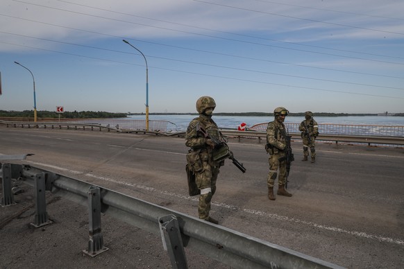 epa09962108 A picture taken during a media tour organized by the Russian Army shows Russian servicemen standing guard near the Kakhovka Hydroelectric Power Plant (HPP) on the Dnieper River in Kakhovka ...