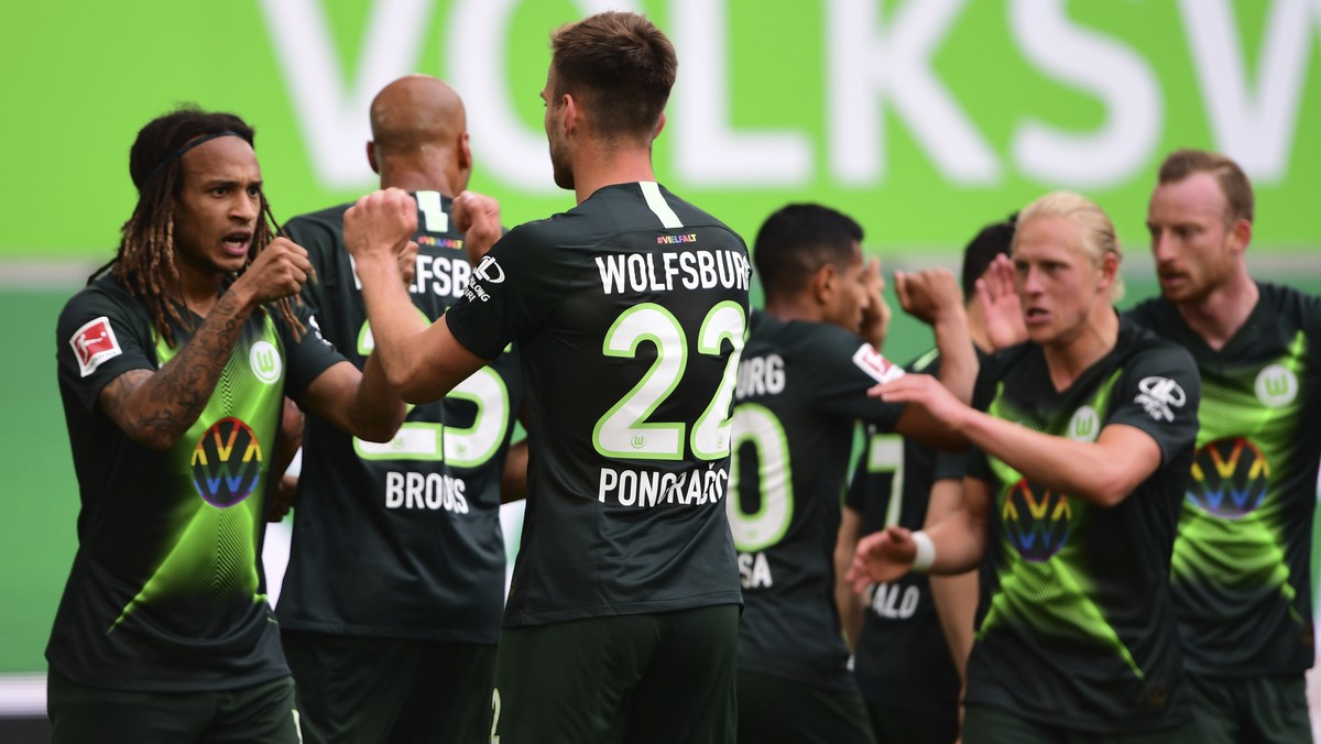 Wolfsburg's Kevin Mbabu, center, celebrates with team mate after scoring during the German Bundesliga soccer match between VfL Wolfsburg and Eintracht Frankfurt in Wolfsburg, Germany, Saturday, M ...
