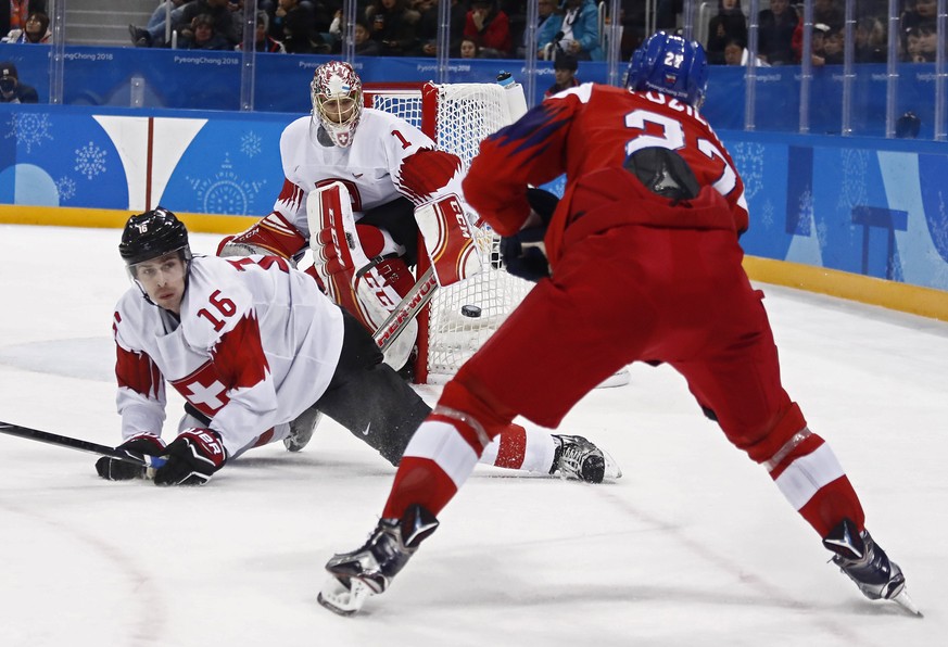 epa06538793 Martin Ruzicka (R) of Czech Republic takes a shot against goalie Jonas Hiller (rear) and Raphael Diaz (C) of Switzerland during the men&#039;s Ice Hockey preliminary round match between Cz ...