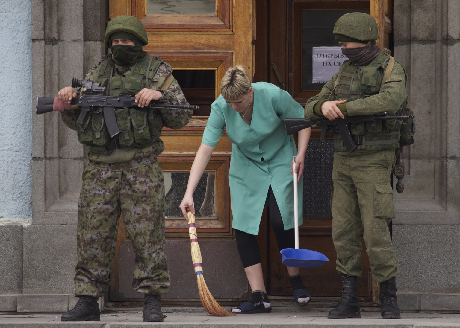 Eine Frau wischt vor einem Hauseingang in Simferopol.