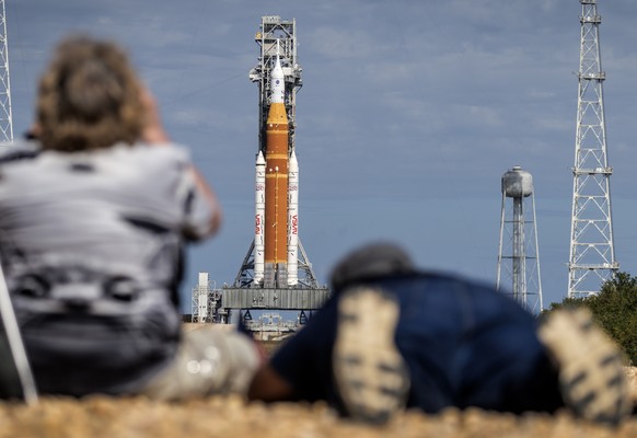 epa12693138 Members of the media photograph the Space Launch System (SLS) rocket with an Orion capsule, part of the Artemis 2 mission, that is docked at Launch Pad 39B at the Kennedy Space Center in T ...
