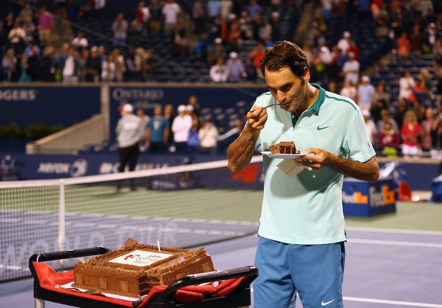 TORONTO, ON - AUGUST 08: Roger Federer of Switzerland has a piece of his birthday cake after a quarterfinals win against David Ferrer of Spain during Rogers Cup at Rexall Centre at York University on  ...