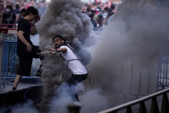 Protesters clash with police as they block the road trying to disrupt the twenty-first stage of the Spanish cycling race La Vuelta, from Alalpardo to Madrid, Spain, Sunday, Sept. 14, 2025. (AP Photo/M ...