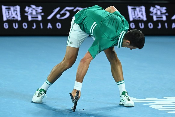 epa09015906 Novak Djokovic of Serbia smashes his tennis raquet during his Men's Quarter finals singles match against Alexander Zverev of Germany on Day 9 of the Australian Open at Melbourne Park in Me ...