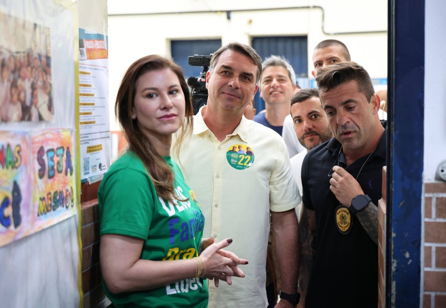 261004 -- BRASILIA, Oct. 4, 2026 -- Flavio Bolsonaro 2nd L, presidential candidate of Brazil s Liberal Party, is seen with his wife 1st L at a polling station in Rio de Janeiro, Brazil, Oct. 4, 2026.  ...