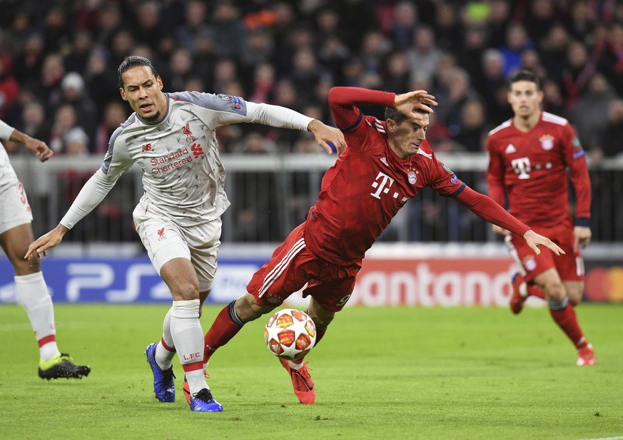 Bayern forward Robert Lewandowski, right, duels for the ball with Liverpool defender Virgil Van Dijk during the Champions League round of 16 second leg soccer match between Bayern Munich and Liverpool ...