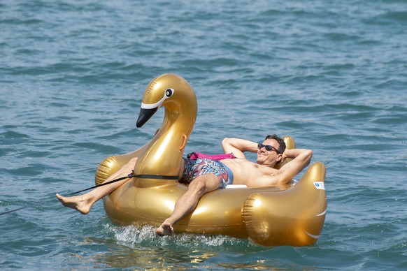 epa06873903 A man enjoys the summer day on Lake Zurich near Thalwil, Switzerland, 08 July 2018. EPA/WALTER BIERI