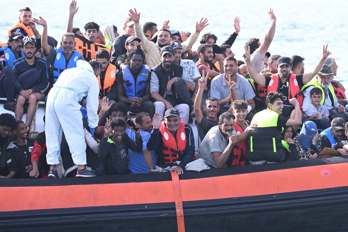 epa10868024 Migrants crowd the deck of the Italian Coast Guard patrol boat CP327 as it arrives in the port of Lampedusa, 18 September 2023. More than 1,000 migrants remain in the hotspots of Lampedusa ...