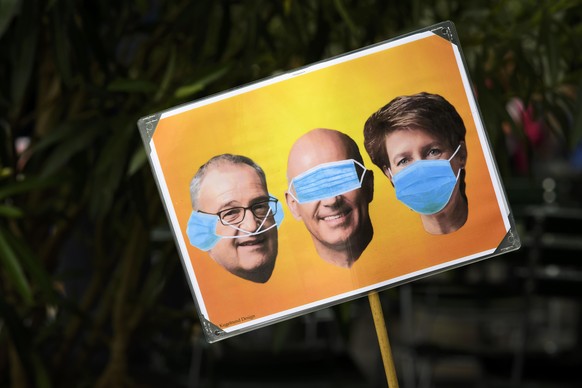 Demonstrators with a poster of three federal councillors at a protest against the Coronavirus lockdown in Bern, Switzerland, 23 May 2020. In Switzerland from 11 May, loosening measures slowing down th ...