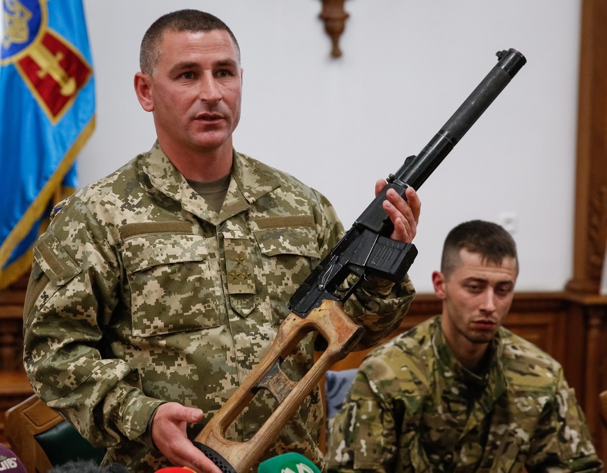 Ukrainische Militärs präsentieren die Waffe, die einer der beiden Festgenommenen bei der Verhaftung auf sich getragen haben soll.