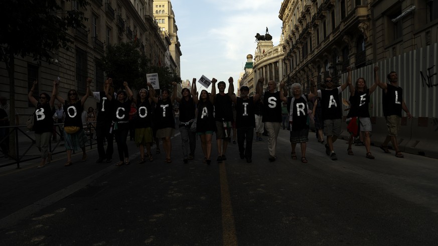 People march on the streets, displaying T-shirts reading ' Boycot Israel' as they shout anti Israeli slogans, during a protest against the Israeli airstrikes of the Gaza strip, in Madrid, Spain, Thurs ...