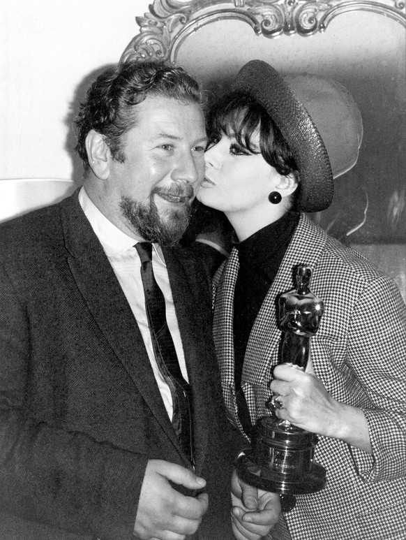 Der Schauspieler Peter Ustinov bekommt einen Kuss von Sophia Loren, als sie ihm seinen Oscar überreicht, 9. Mai 1965, Paris.