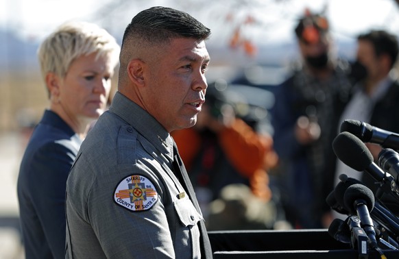 Santa Fe County Sheriff Adan Mendoza, front, speaks Santa Fe District Attorney Mary Carmack-Altwies, rear, listens during a news conference in Santa Fe, N.M., Wednesday, Oct. 27, 2021. New Mexico auth ...
