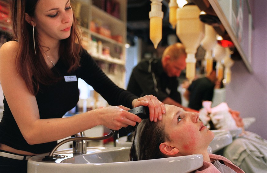Ein Coiffeur-Lehrling waescht am 23. April 2003 einer Kundin die Haare im Coiffeur Salon Coiffina in Zuerich. (KEYSTONE/Gaetan Bally) : FILM]