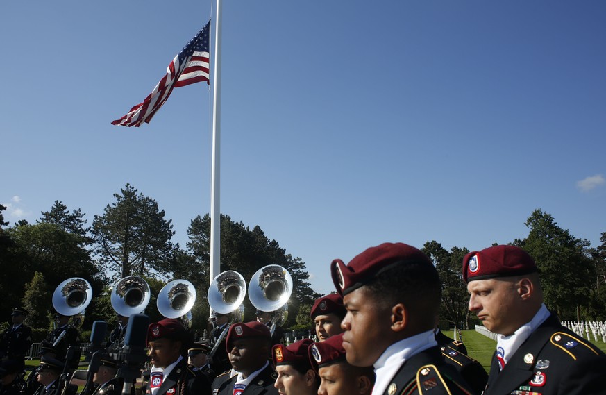 US Army soldiers, based in Germany, stand near the American flag prior to a ceremony to mark the 75th anniversary of D-Day at the Normandy American Cemetery in Colleville-sur-Mer, Normandy, France, Th ...