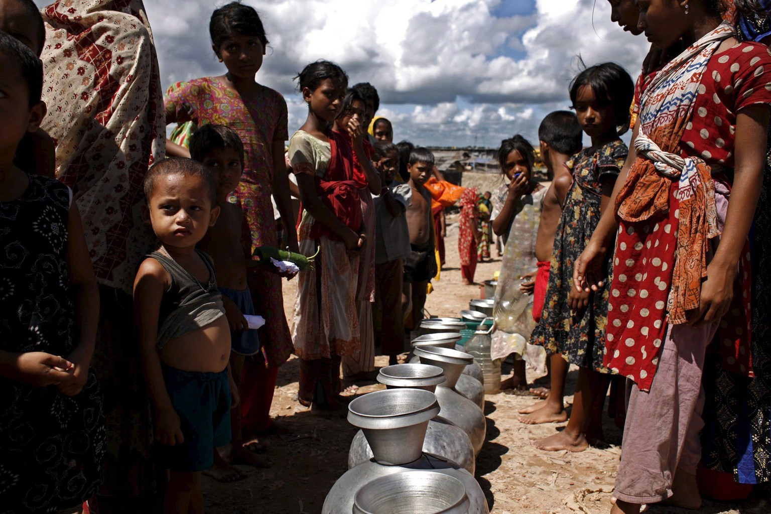 epa01047060 A large numbers of slum people are in an queue collecting drinking water supplied by Army soldiers at the downtown Mohammadpur, Dhaka, Bangladesh, 25 June 2007. Drinking water is a regular ...