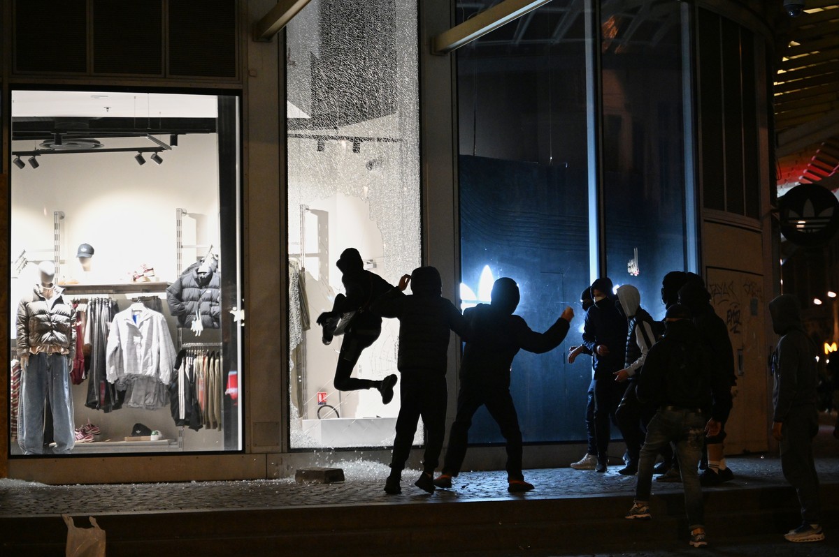 KEYPIX - Youths break a store window during clashes between protestors and police in Paris, Sunday, Oct. 18, 2026. (KEYSTONE/AP Photo/Emma Da Silva)