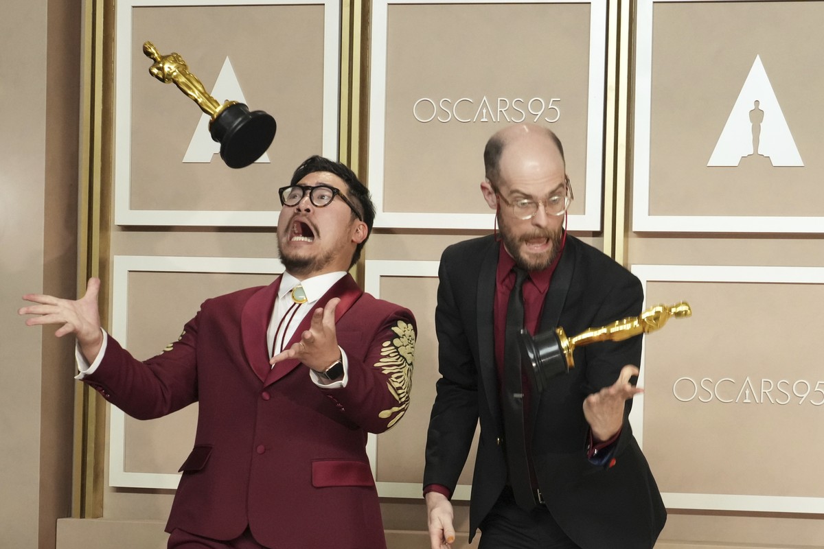 Daniel Kwan, left, and Daniel Scheinert toss their awards for best picture for "Everything Everywhere All at Once" as they pose in the press room at the Oscars on Sunday, March 12, 2023, at  ...