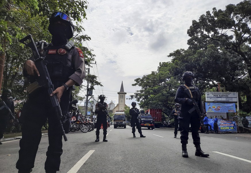 epa09102596 Police officers stand guard near the Sacred Heart of Jesus Cathedral in the aftermath of an explosion in Makassar, South Sulawesi, Indonesia, 28 March 2021. At least nine people were wound ...