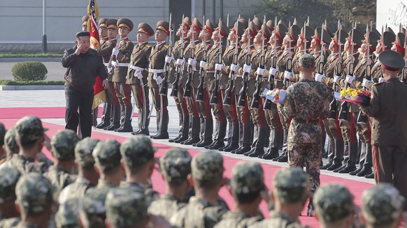 In this photo provided by the North Korean government, North Korean leader Kim Jong Un, left on red carpet, visits the headquarters of the North Korean People?s Army?s 2nd Corps at an undisclosed plac ...