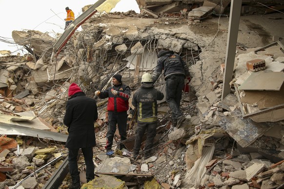 Rescue workers search for survivors on a collapsed building in Malatya, Turkey, Tuesday, Feb. 7, 2023. Search teams and aid are pouring into Turkey and Syria as rescuers working in freezing temperatur ...