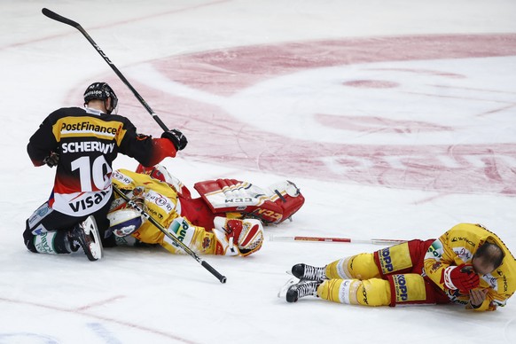 Biels Torhueter Jonas Hiller, Mitte, und Robbie Earl, rechts, liegen nach einem Zusammenprall mit Berns Tristan Scherwey, links, auf dem Eis, im siebten Eishockey Playoff-Halbfinalspiel der National L ...