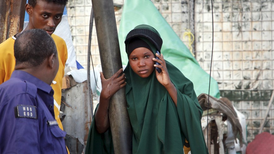 A Somali girl cries and speaks on her phone as she tries to locate her missing mother, at the scene of a bomb blast near the Sahafi hotel in the capital Mogadishu, Somalia Friday, Nov. 9, 2018. Four c ...