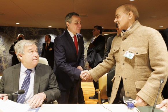 Swiss Foreign Minister Ignazio Cassis, centre, shakes hand with Prime Minister of Pakistan Shehbaz Sharif, right, past U.N. Secretary-General Antonio Guterres, left, prior the International Conference ...
