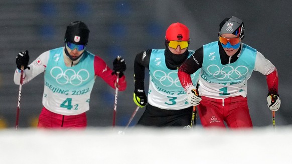 epa09765623 (fromi L) Hideaki Nagai of Japan, Julian Schmid of Germany and Johannes Lamparter of Austria in action during the Cross Country segment of the Men&#039;s Nordic Combined Large Hill/4x5km T ...