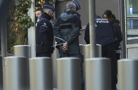 Police detain a climate activist during a demonstration outside an EU summit meeting in Brussels, Thursday, Dec. 12, 2019. Greenpeace activists on Thursday scaled the European Union's new headqua ...