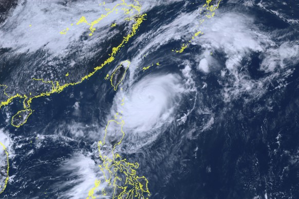 This satellite image taken by Himawari-8, a Japanese weather satellite, and provided by the National Institute of Information and Communications Technology, shows Typhoon Koinu, center, approaching Taiwan...