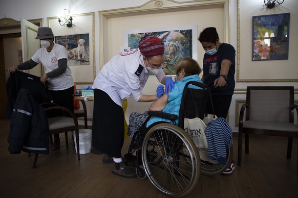 An Israeli woman receives the second Pfizer-BioNTech COVID-19 vaccine at a private nursing home, in Ramat Gan, Israel, Wednesday, Jan. 13, 2021. Israel has struck a deal with Pfizer, promising to shar ...