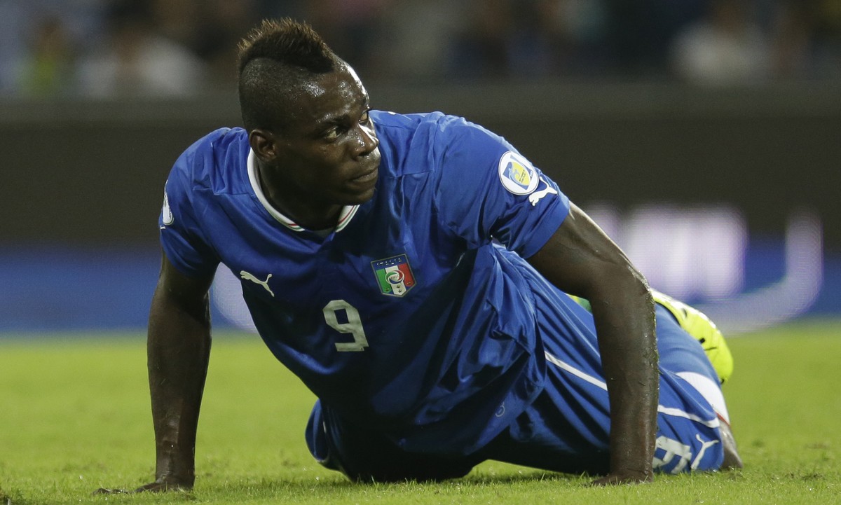 FILE - In this Oct. 15, 2013, file photo, Italy's Mario Balotelli lies on the pitch during a 2014 FIFA World Cup, Group B, qualification match between Italy and Armenia in Naples, Italy. Italy  ...