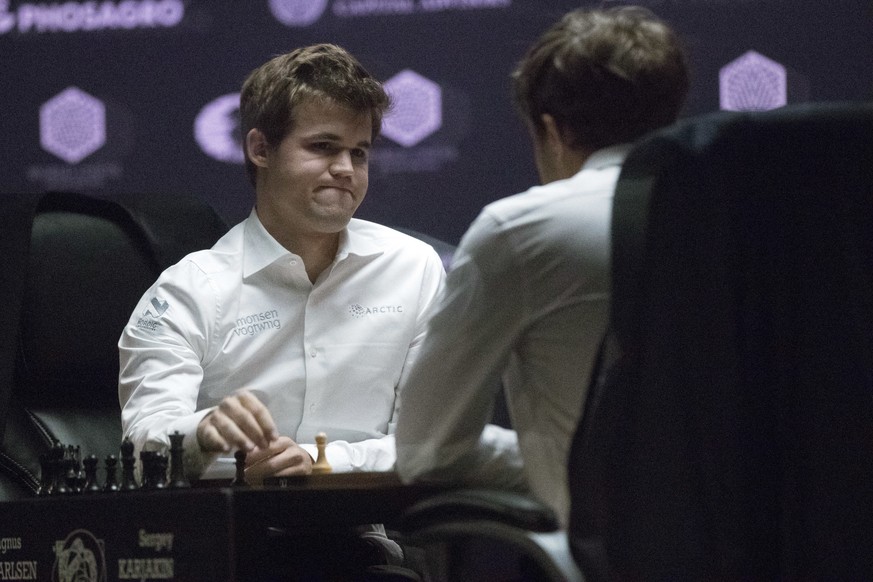 Defending champion Magnus Carlsen, left, reacts after Sergey Karjakin, of Russia, forces a draw during the tie breaker round of the World Chess Championship, Wednesday, Nov. 30, 2016, in New York. (AP ...