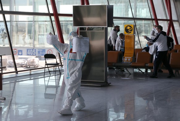 epa09724719 Airport staff wear protective gear at the Beijing International Airport on the eve of the 2022 Winter Olympic Games opening in Beijing, China, 03 February 2022. EPA/Grzegorz Momot POLAND O ...