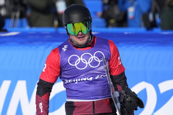 Switzerland&#039;s Kalle Koblet carries his board during the men&#039;s cross finals at the 2022 Winter Olympics, Thursday, Feb. 10, 2022, in Zhangjiakou, China. (AP Photo/Lee Jin-man)