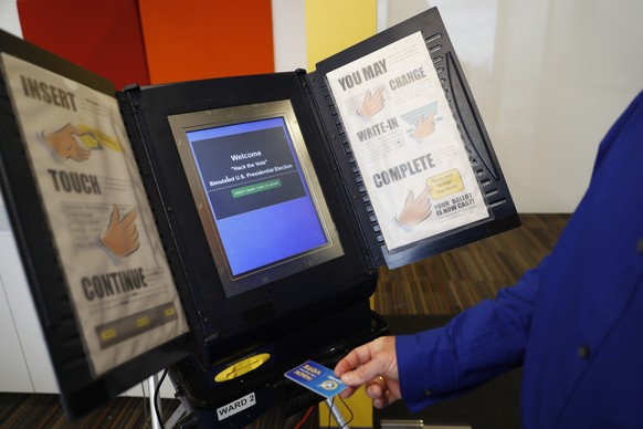 FILE - In this Wednesday, Sept. 28, 2016 file photo, Brian Varner, a principal researcher at Symantec, inserts an identifying chip card into an electronic voting machine as he demonstrates how to hack ...