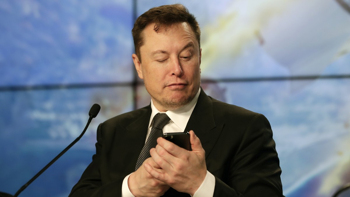 FILE - Elon Musk founder, CEO, and chief engineer/designer of SpaceX jokes with reporters as he pretends to search for an answer to a question on a cell phone during a news conference after a Falcon 9 ...