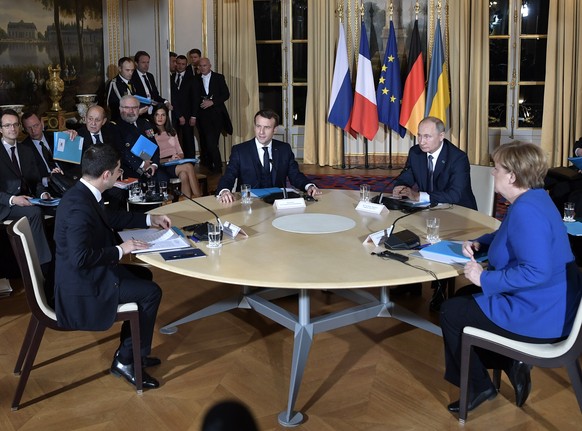 epa08057922 (L-R) Ukrainian President Volodymyr Zelensky, French President Emmanuel Macron, Russian President Vladimir Putin, and German Chancellor Angela Merkel at for the roundtable during a summit  ...