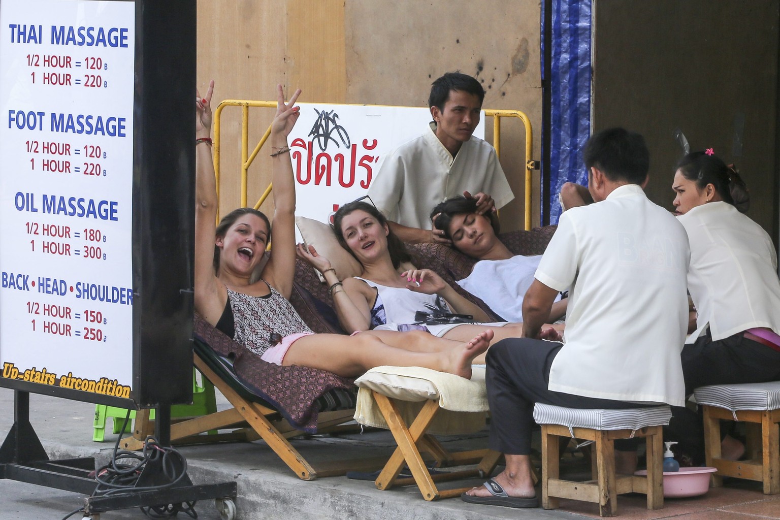 Touristinnen lassen sich in Bangkok Füsse und Kopf massieren.