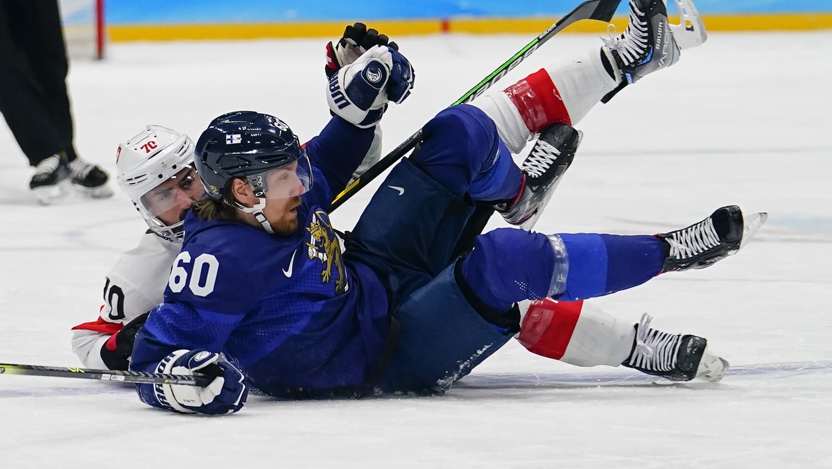 Finland's Markus Granlund (60) and Switzerland's Denis Hollenstein (70) fall during a men's quarterfinal hockey game at the 2022 Winter Olympics, Wednesday, Feb. 16, 2022, in Beijing. ( ...