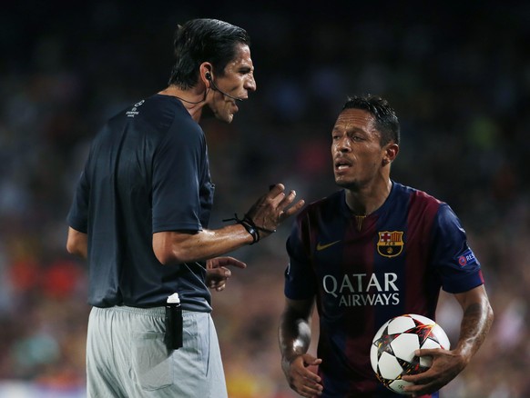 Referee Deniz Aytekin from Germany speaks to Barcelona&#039;s Dani Alves during the Champions League Group F soccer match between Barcelona and Apoel at the Camp Nou stadium in Barcelona, Spain, Wedne ...