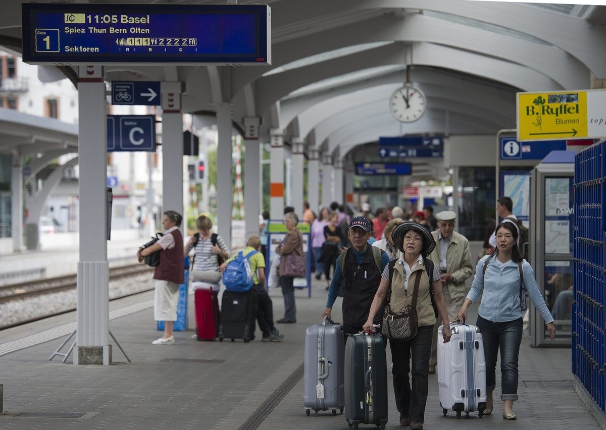Asiatische Touristen warten auf den Zug, am Samstag 6. August 2011, in Interlaken West. Der starke Schweizer Franken macht der Tourismusbranche Sorgen und haelt die Touristen fern. (KEYSTONE/Peter Sch ...