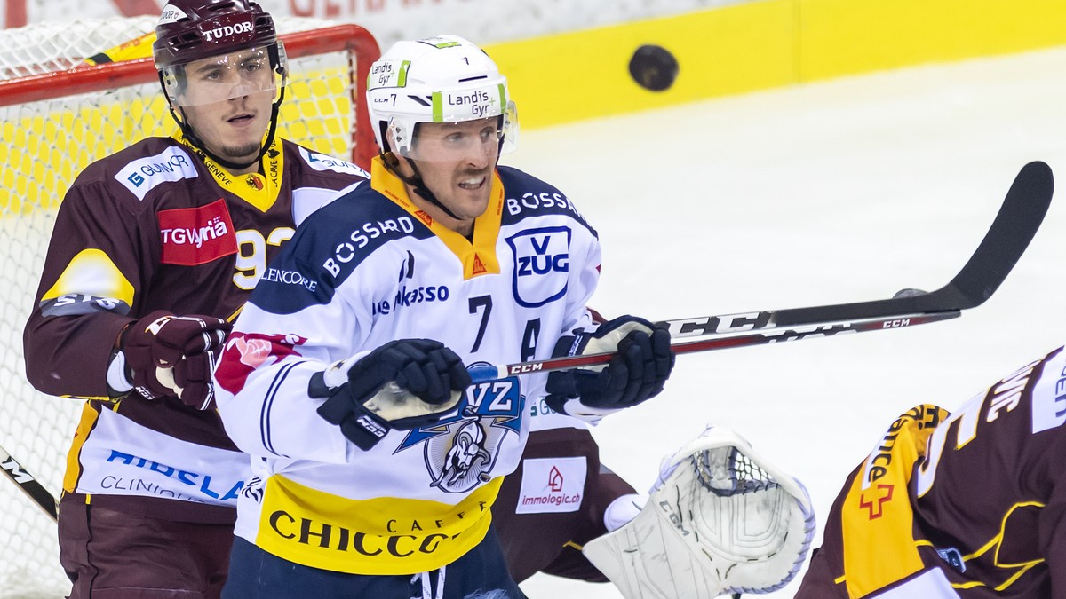 Le joueur zougois, David Mclntyre, droite, a la lutte pour le puck avec le joueur genevois, Eliot Berthon, gauche, lors du match du championnat suisse de hockey sur glace de National League, entre le  ...