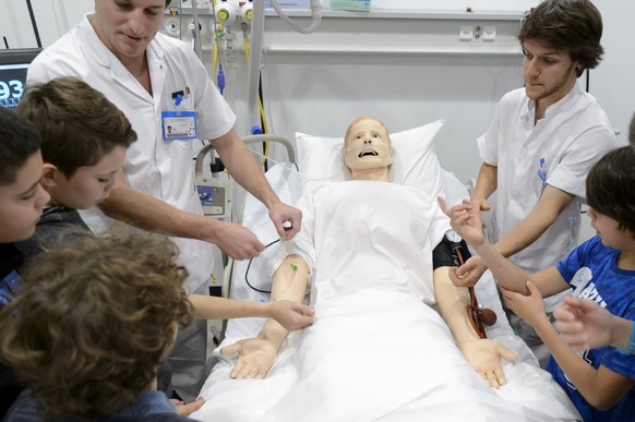 Un infirmier montre son metier en expliquant le fonctionnement d&#039;un robot patient &quot;Jean-Pierre&quot; a des enfants lors d&#039;un atelier de la Journee Oser tous les metiers ce jeudi 12 nove ...