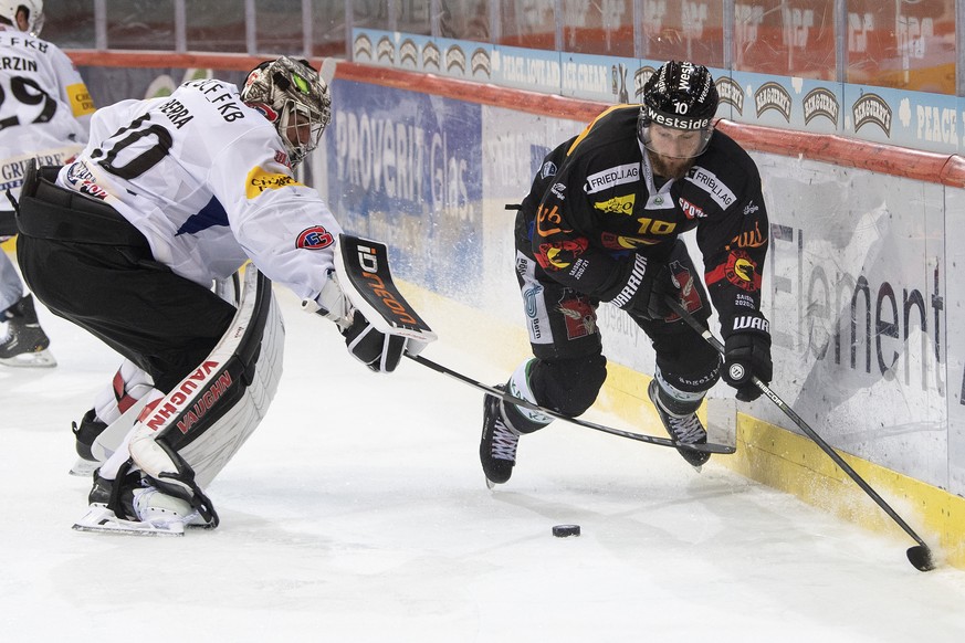 Berns Tristan Scherwey, rechts, im Duell mit Gotterons Torhueter Reto Berra im Eishockey Meisterschaftsspiel der National League zwischen dem SC Bern und dem HC Fribourg-Gotteron, am Samstag, 31. Okto ...