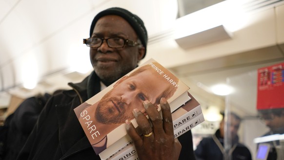 A customer has copies of the new book requested by Prince Harry "Save" in a bookshop during a midnight opening in London, Tuesday, January 10, 2023. Prince Harry's memoir ?Spare?  arrives in b...
